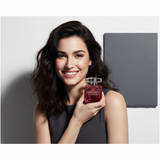 Portrait of Margaux Laurent, a young woman, holding the pink Jimmy Choo Blossom Eau de Parfum. She looks confident, with an e